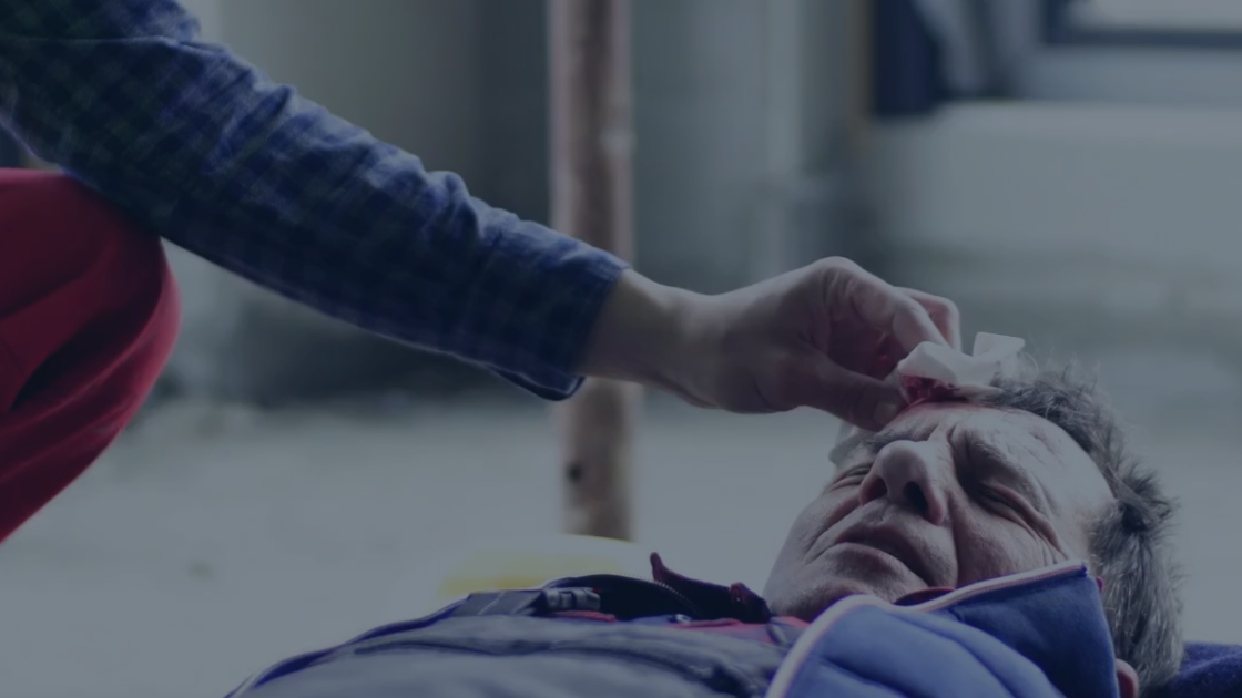 First aid being administered to an injured worker at a jobsite, illustrating incident response and hazard control on a Joint Health and Safety Committee.